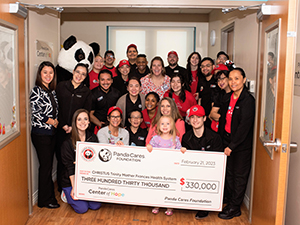 Tyler associates receiving a Panda Cares check