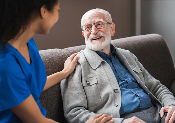 Young friendly African female caregiver with a senior elderly man